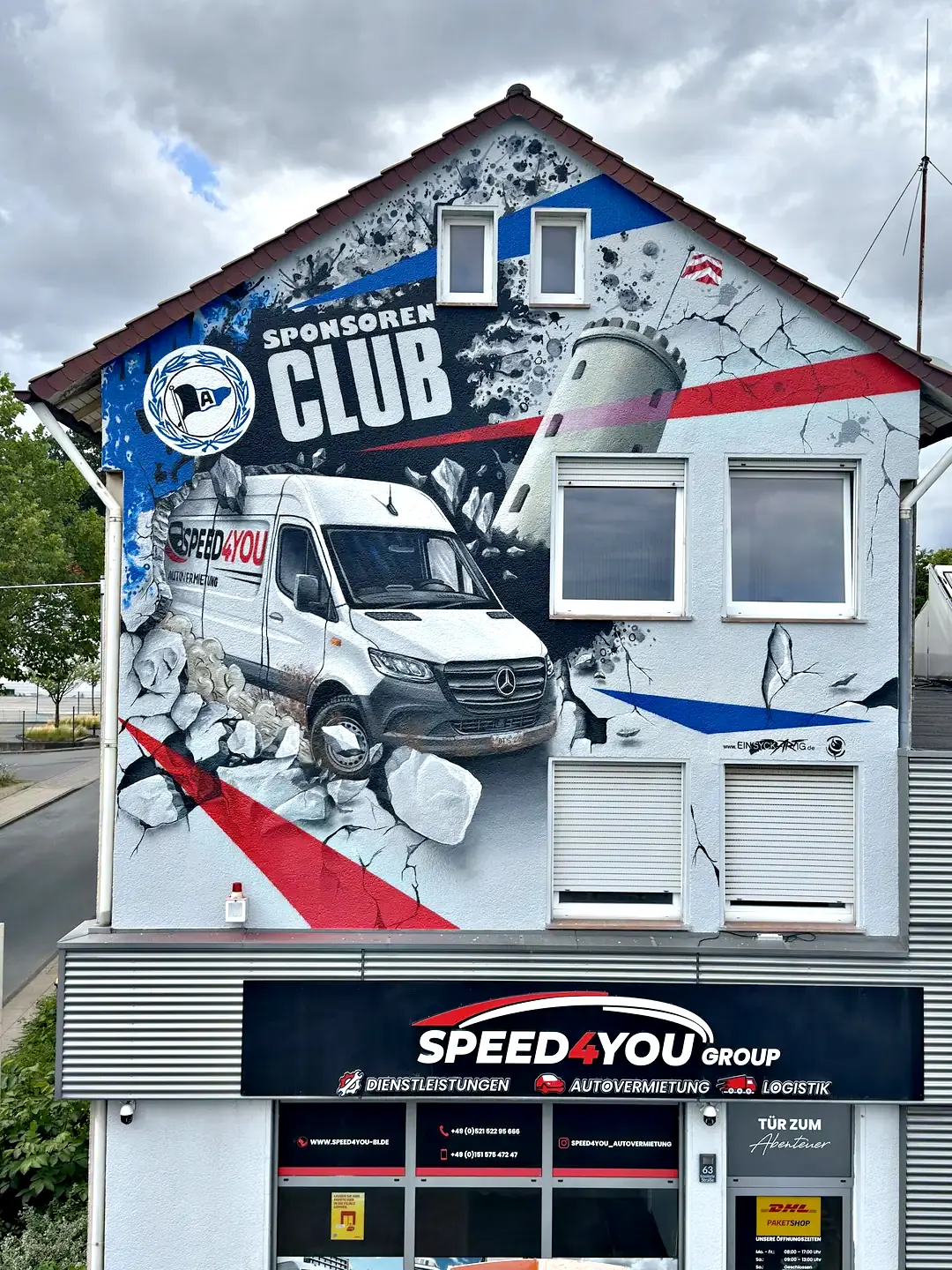 Das Gebäude an der Eckendorfer Straße 63: der gemalte Sprinter bricht aus der Giebelwand, darunter das Firmenschild der Speed4you Group und die Geschäftsstelle.